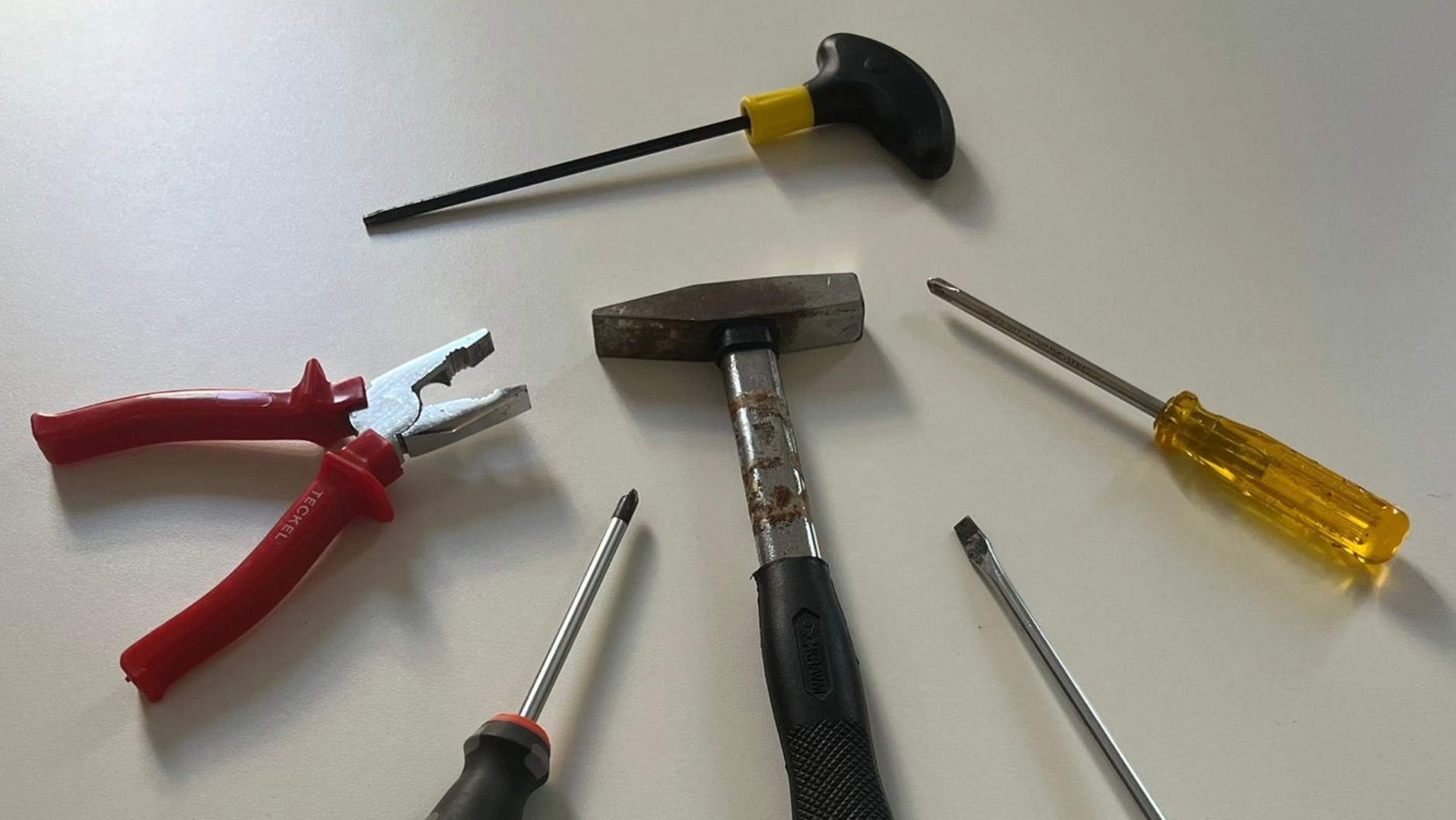 Set di attrezzi da ferramenta che rimandanoalla fiera TOOL JAPAN: un martello, una pinza spelafili e due cacciaviti.