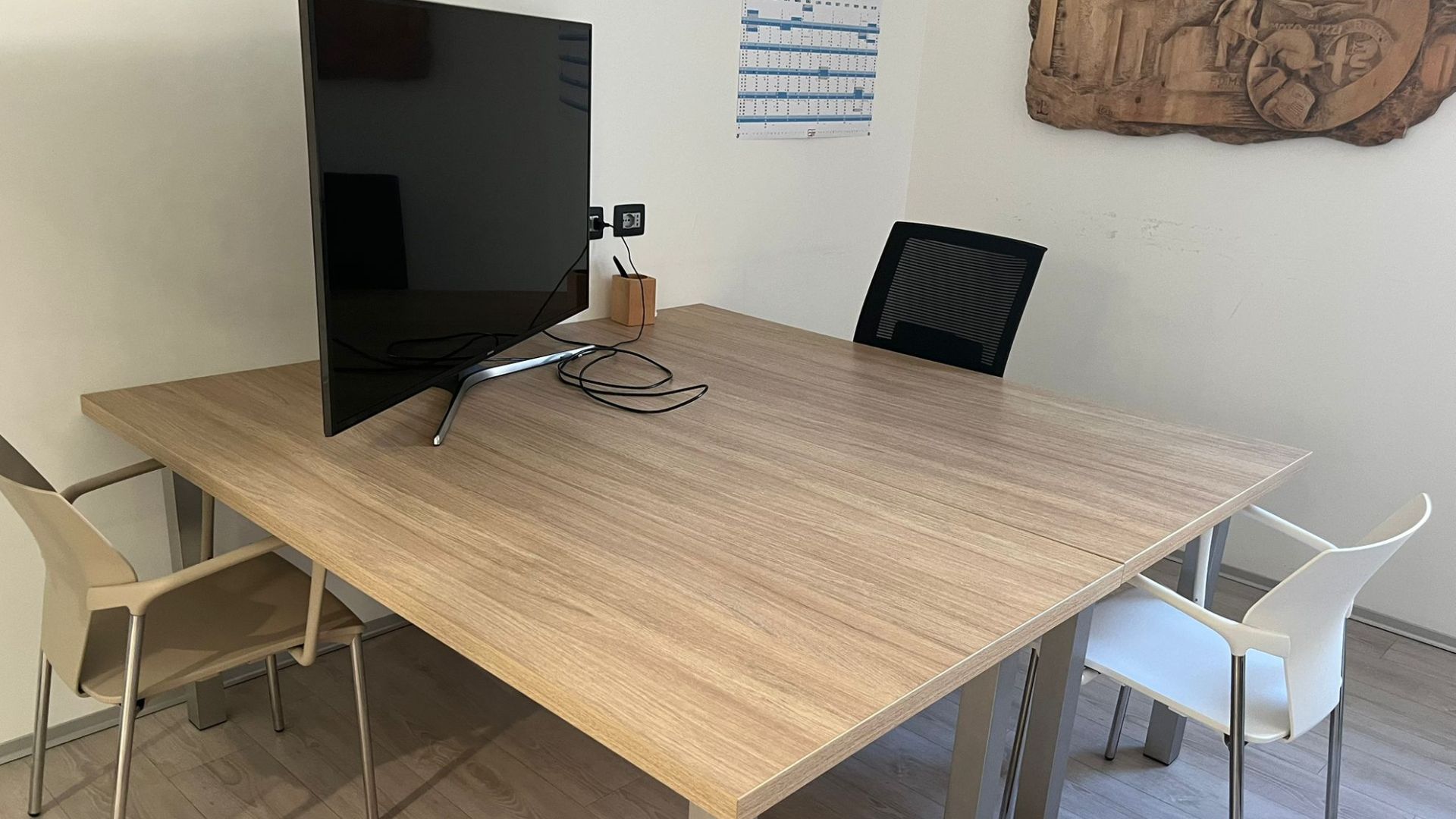 Tavolo in sala riunioni CED INGEGNERIA con due sedie e tv conforme a Le agevolazioni fiscali per gli interventi edilizi