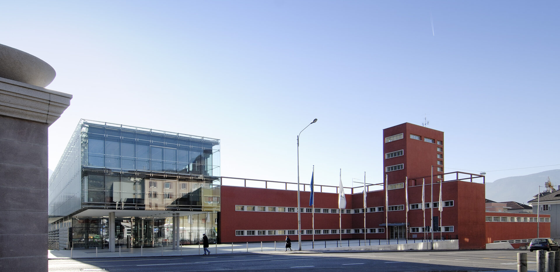 Sede di Eurac Research a Bolzano con la moderna facciata in vetro e la storica struttura in intonaco rosso